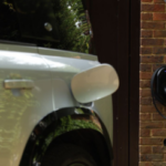 Land Rover parked on a driveway plugged into a charger and charging.